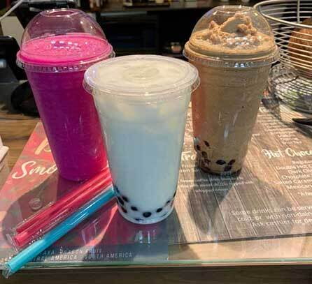 dragon fruit smoothie, coconut boba tea, mocha coffee boba tea sitting on counter with fat boba tea straws